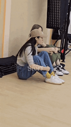 two women are sitting on the floor with the word story on the bottom
