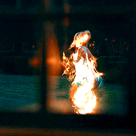a person is on fire in a dark room with a reflection