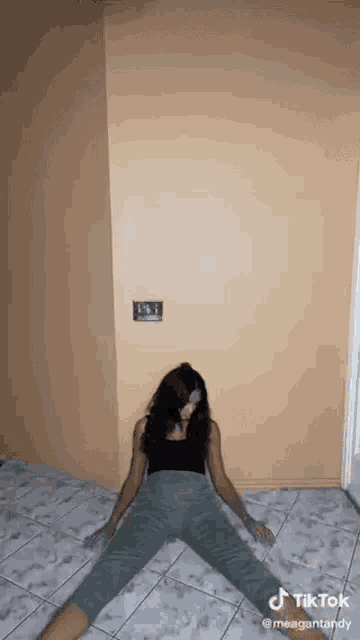 a woman is laying on the floor with her legs crossed and her head on the floor .