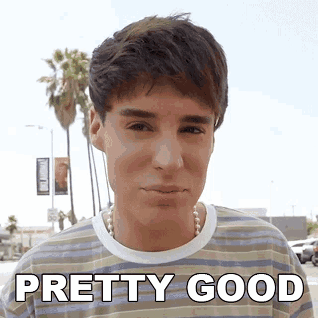 a man wearing a striped shirt and pearls says " pretty good "