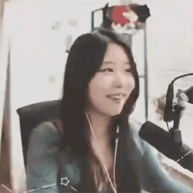a woman is sitting in front of a microphone wearing headphones .