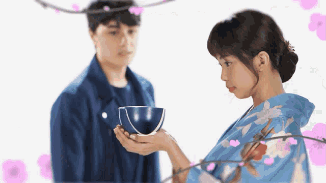 a woman in a blue kimono is holding a bowl in front of a man in a blue jacket