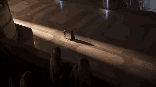 a group of people standing in a dark room with a shadow of a person on the ground
