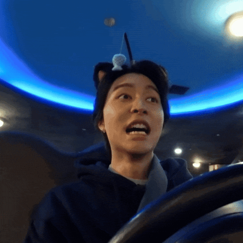 a person with a cat ear on their head is driving a car