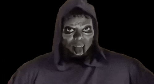 a man in a hooded sweatshirt with a mask on his face is making a funny face