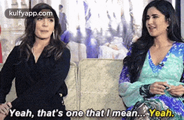 two women are sitting next to each other on a couch and one of them is talking to the other .