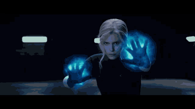 a woman in a superhero costume is surrounded by blue energy