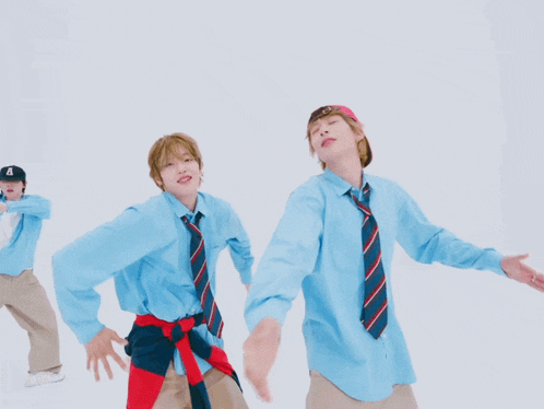 two boys wearing blue shirts and ties are posing for a picture