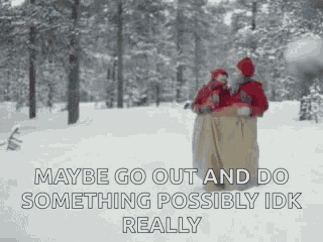 a couple of people standing in the snow with a blanket on .
