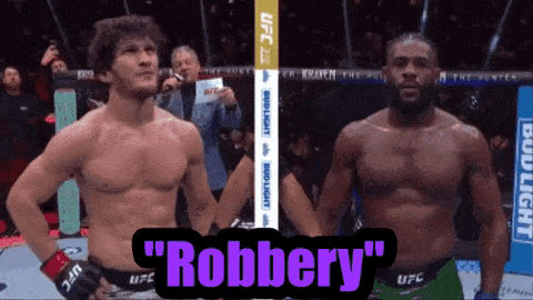 two men standing next to each other in a boxing ring with the words " robbery " above them