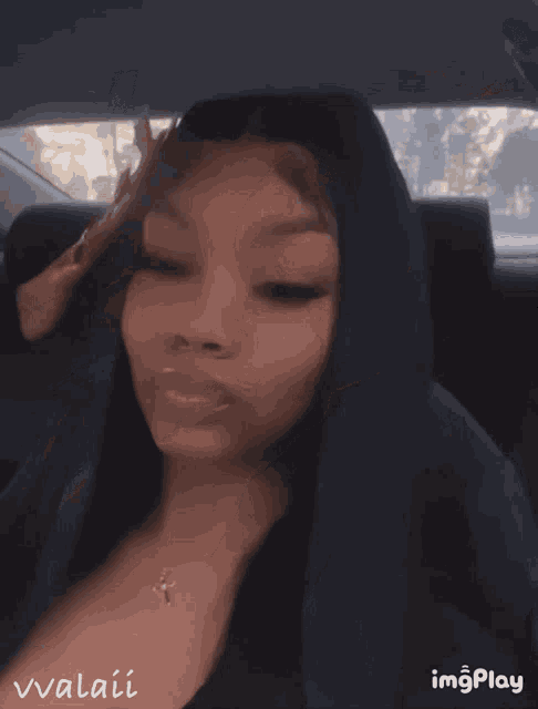 a woman sitting in the back seat of a car with her eyes closed and the name vvalai on the bottom