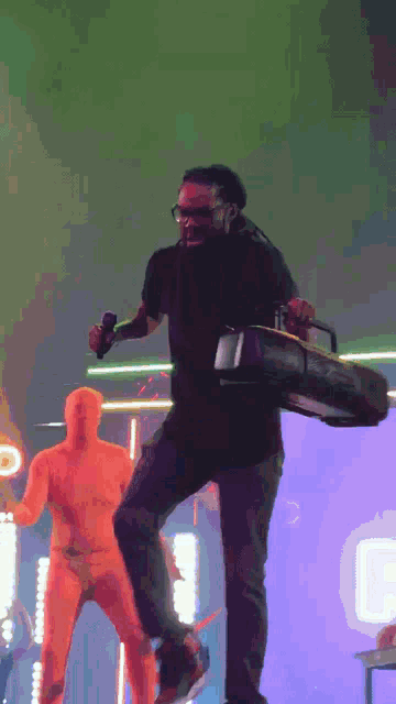 a man in a black shirt is holding a boombox and a microphone