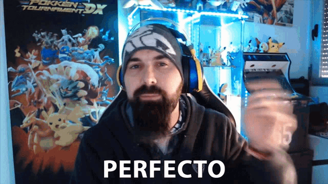 a man with a beard is sitting in front of a poster that says pokken tournament dx