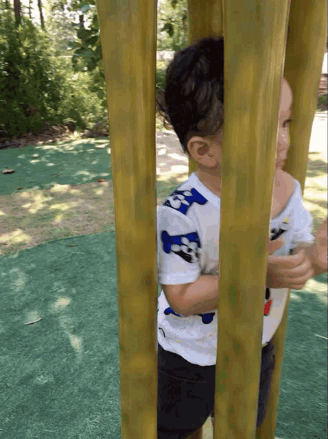 a young boy wearing a white shirt with a blue and white shark on it
