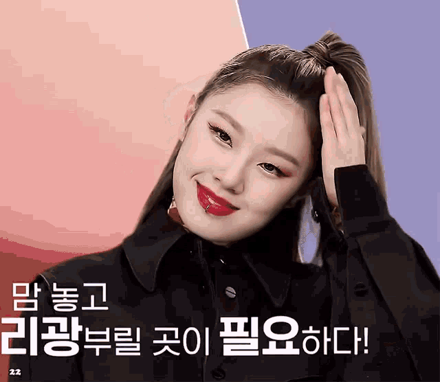 a woman with a ponytail and red lipstick is smiling and holding her hair