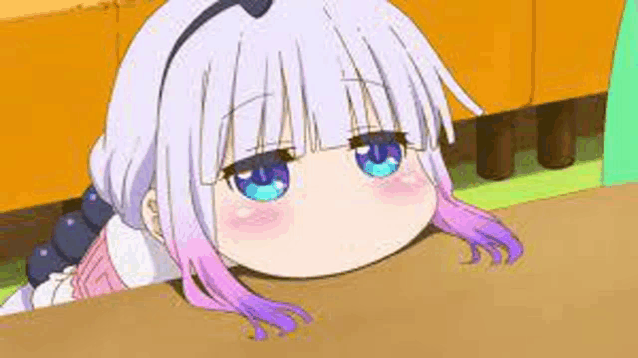a little girl with purple hair and blue eyes is laying on a table .