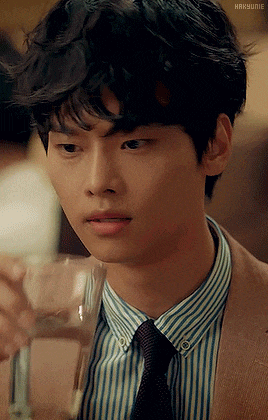 a man in a suit and tie is holding a glass of wine
