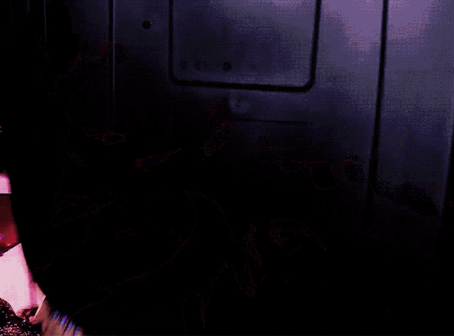 a group of people are looking up at something in a purple room