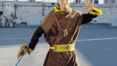 a man in a costume holds a blue sword