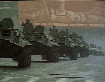 a row of military vehicles are lined up in front of a billboard that says ' cccp ' on it