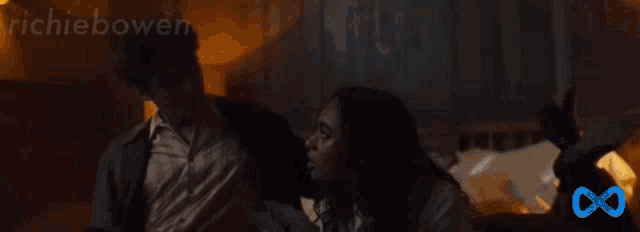 a man and a woman are laying on a bed with the words richiebowen written above them