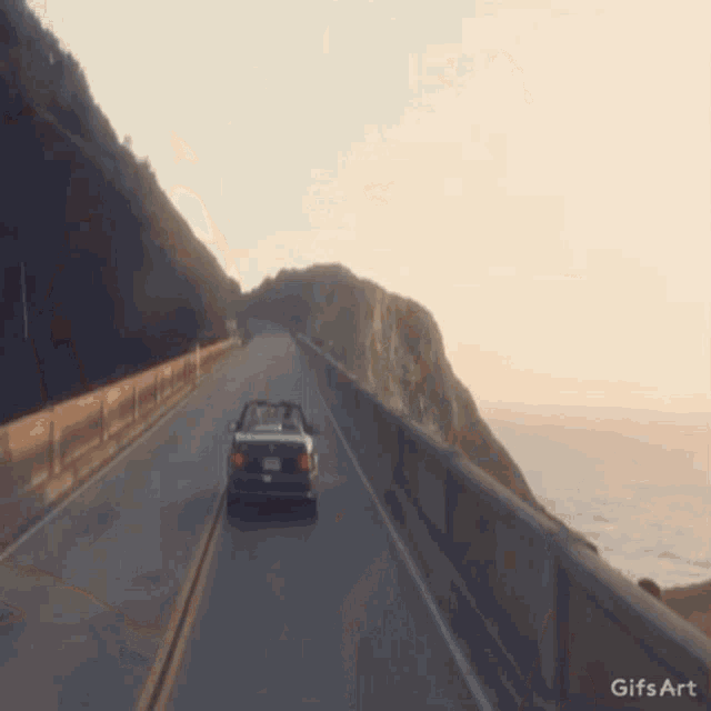 a gif of a car driving down a road with the words gifs art below it