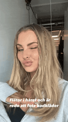a woman with blonde hair and a caption that says " flator i haret och ar redo att fota badklader "