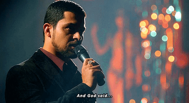 a man singing into a microphone with the words " and god said " below him
