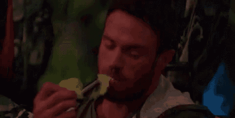 a man is eating a piece of food with a fork and spoon .
