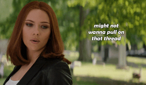 a woman with red hair is standing in a park with the words " might not wanna pull on that thread " above her