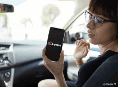 a woman in a car is holding a cell phone that says appmart on the screen