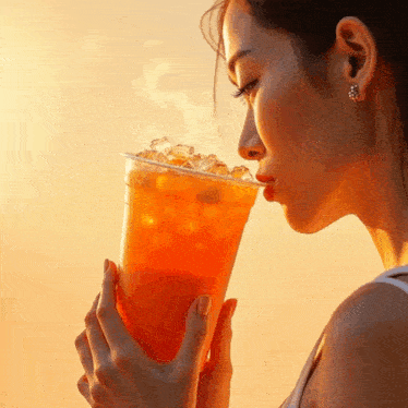 a woman drinking from a plastic cup with ice cubes