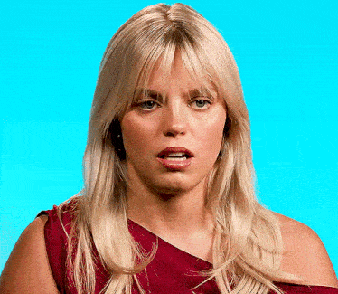 a woman with blonde hair is wearing a red dress and making a funny face