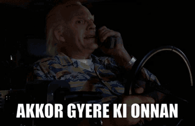 a man driving a car with the words " akkor gyere ki onnan " written on the screen