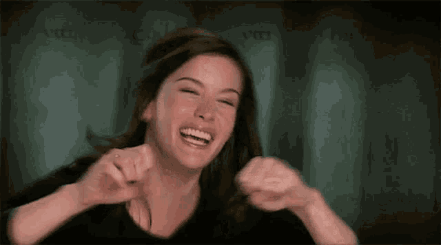 a woman is laughing and pointing at the camera while wearing a ring