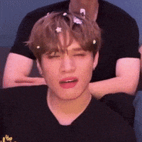 a young man with flowers in his hair is wearing a black shirt that says " after "