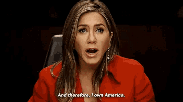 a woman in a red jacket is sitting in a chair and says `` and therefore , i own america . ''