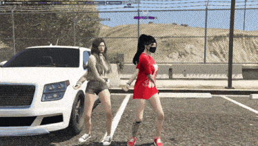 two girls are dancing in a parking lot in front of a car