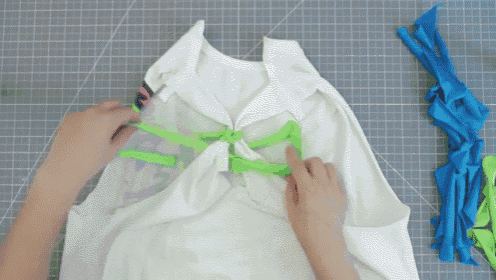 a person is cutting a piece of fabric with a sharp knife on a cutting board