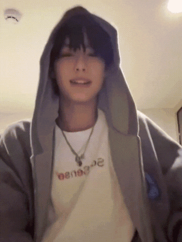 a young man wearing a hoodie and a t-shirt that says ' oenoe ' on it