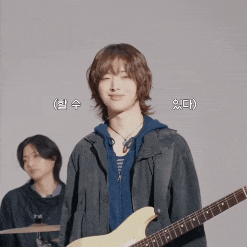 a man playing a guitar with korean writing on the bottom