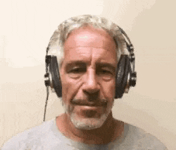 a man with a beard is wearing headphones and making a funny face .