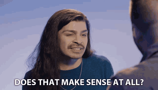 a man with long hair and a mustache talks to another man with the words " does that make sense at all " below him