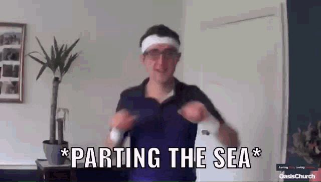 a man wearing a headband and glasses is dancing and says parting the sea