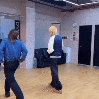 a man and a woman are dancing in a room with a sign that says dvm