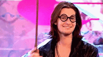 a man with long hair wearing glasses and holding a wand