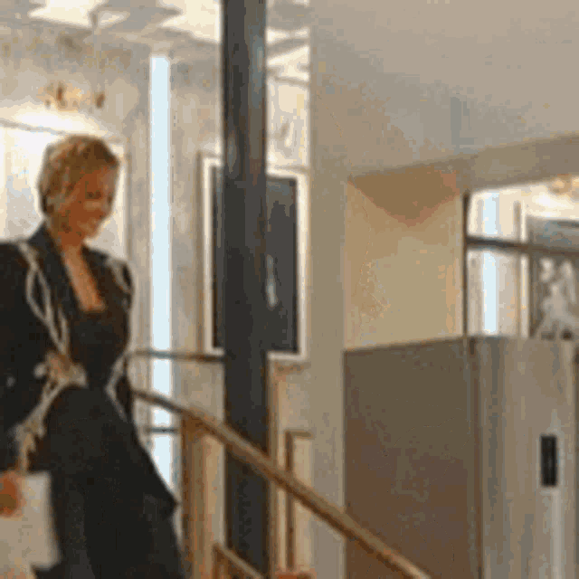 a woman in a black jacket is walking down stairs .