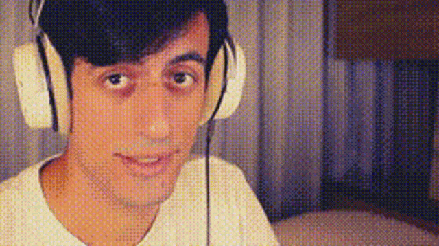 a man wearing headphones looks at the camera