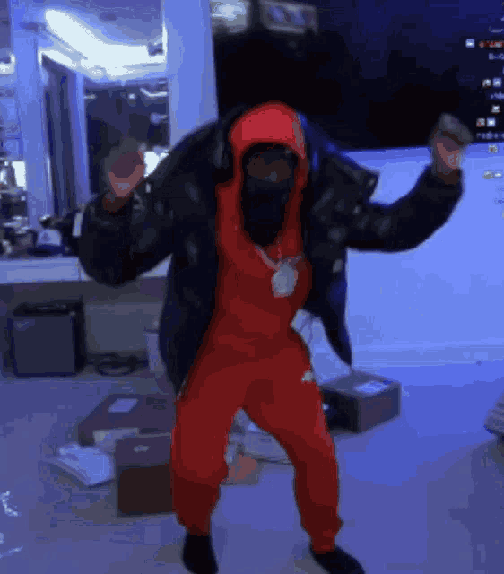a man wearing a red hoodie and red pants is dancing