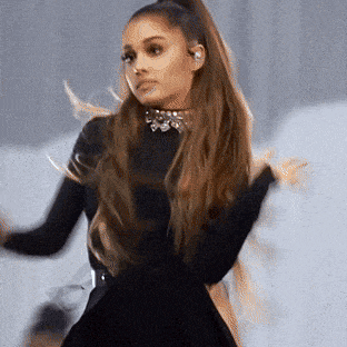 ariana grande is wearing a black dress and a choker necklace while dancing .